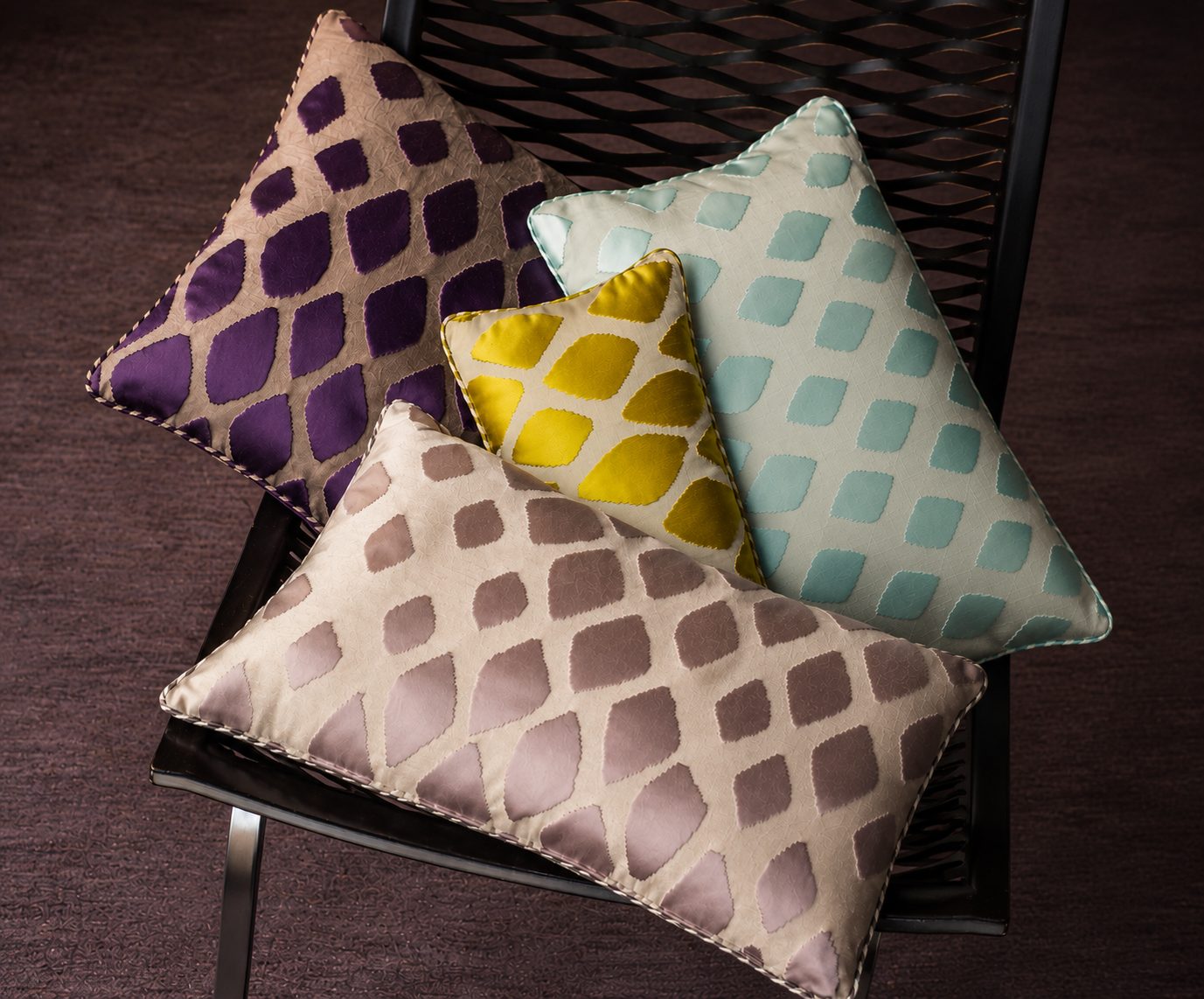 Set of bespoke cushions in cut-velvet geometric patterns — purple, aqua, gold and taupe