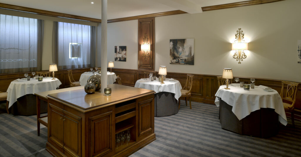 Au Crocodile restaurant dining room — bespoke tablecloths, table lamps, stretched carpeting