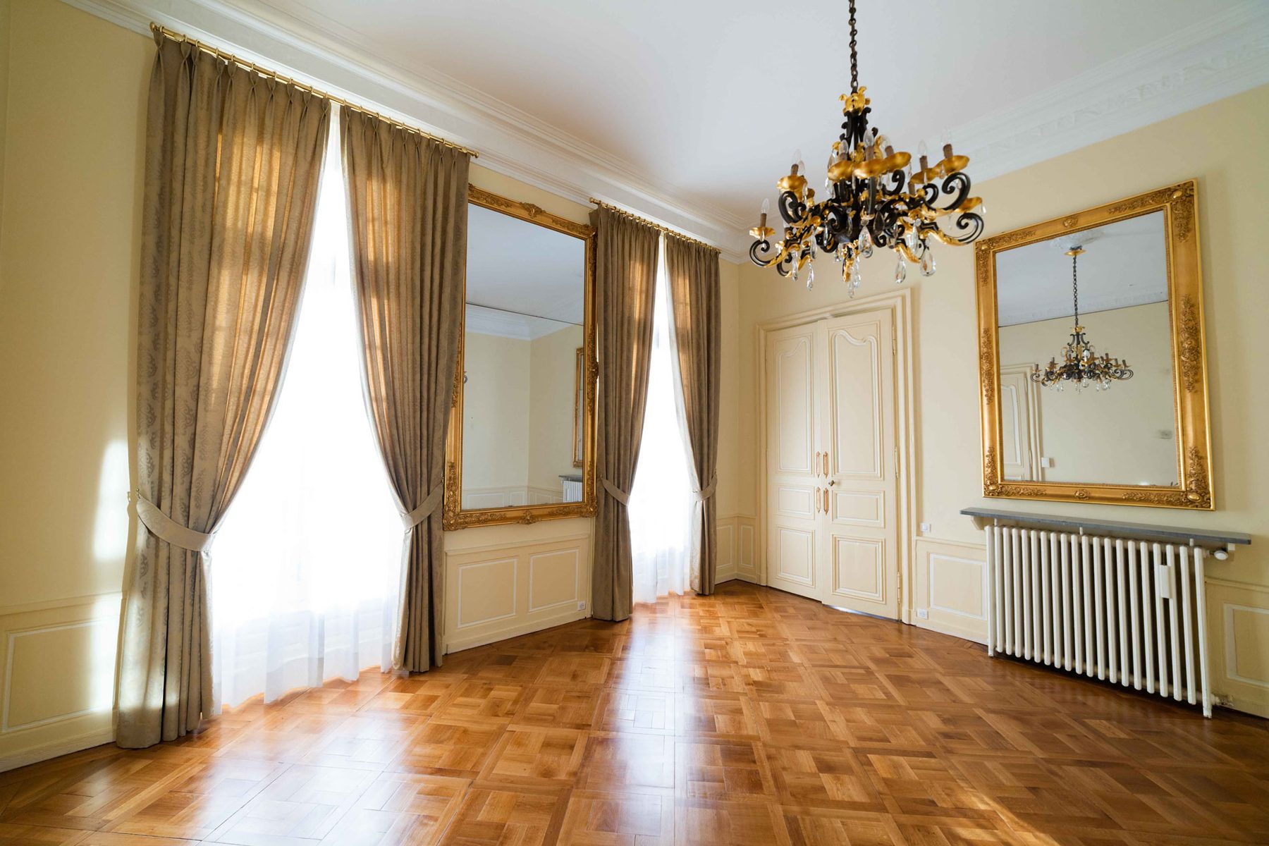 Grand salon of a historical monument with gilt mirrors and chandelier