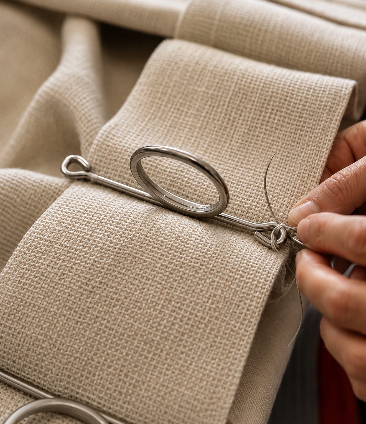 Curtain rings hand-sewn onto a linen heading tape in the atelier