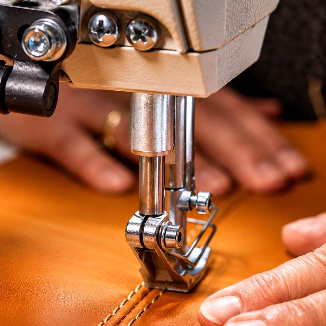Saddle-stitch sewing machine working tan marine leather